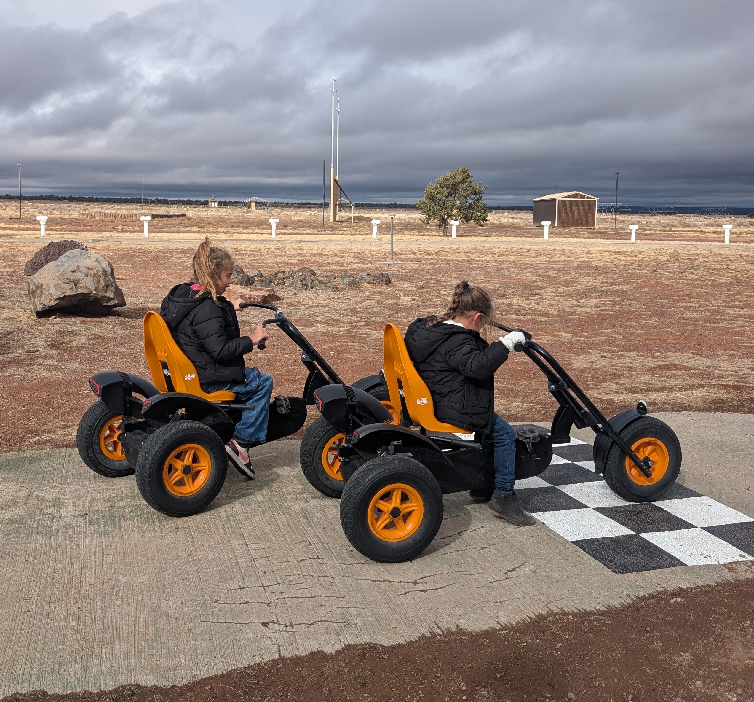 Two kids riding go-carts at Bedrock City, Raptor Ranch Valle Arizona